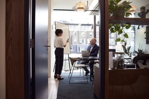 A woman talking to a man in an office.