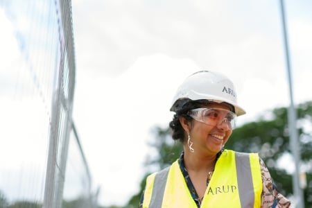 A smiling woman at a construction site.